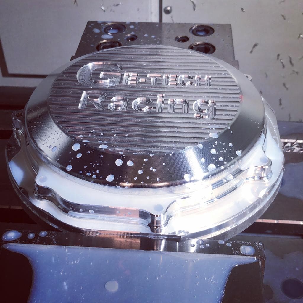 CNC-machined alloy part engraved Ge-Tech Racing in the workshop